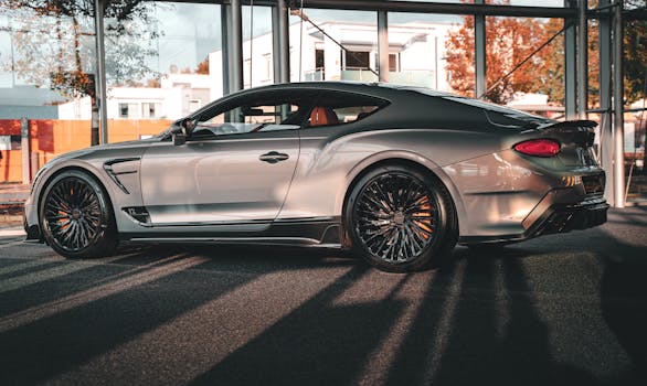 Elegant silver sports car displayed in modern urban environment with autumn sunlight.