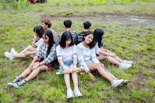A group of teenagers relaxing on grass, enjoying a sunny day together.