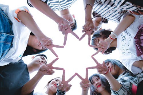 Grupo De Pessoas Formando Estrela Usando As Mãos