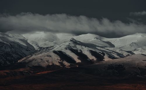 Free Dramatic view of snow-covered mountains under a moody sky, capturing the essence of winter beauty. Stock Photo