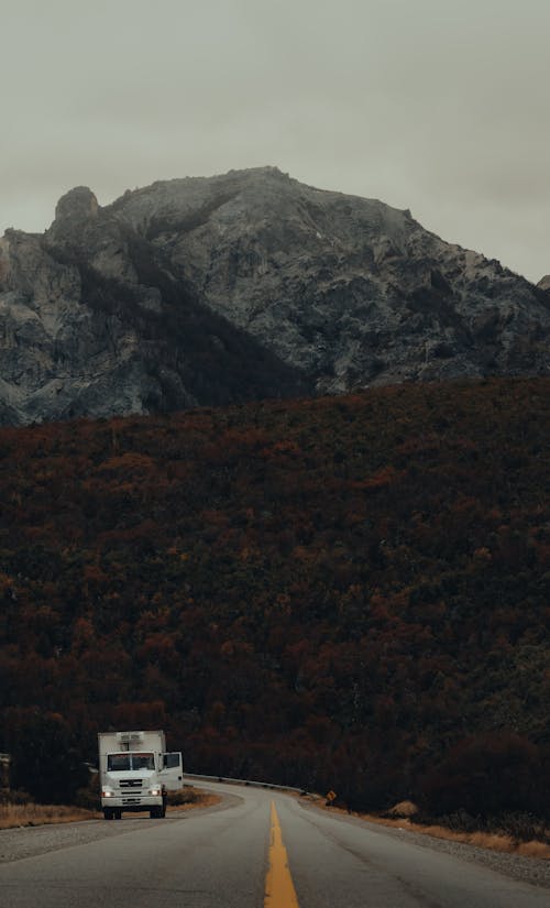 Car on a Road in Front of a Huge Mountain