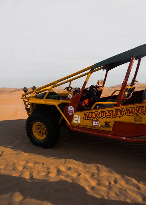 Free Experience an exhilarating dune buggy ride across barren desert sands under a bright sky. Stock Photo