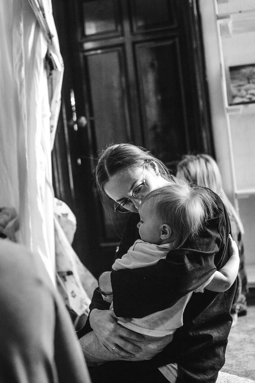Free Black and white photo of a mother lovingly holding her child indoors. Stock Photo