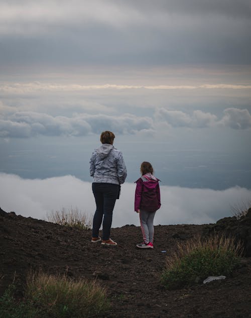 Free A Mother and Daughter Looking at the View on Top of a Mountain Stock Photo