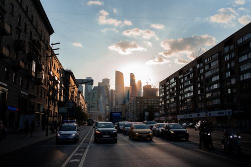 Free Dynamic city street scene at sunset with skyscrapers and traffic in vibrant lighting. Stock Photo