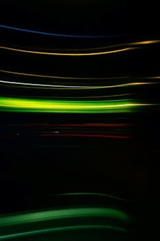 Vibrant abstract light streaks in motion against a dark background create a sense of movement and energy.