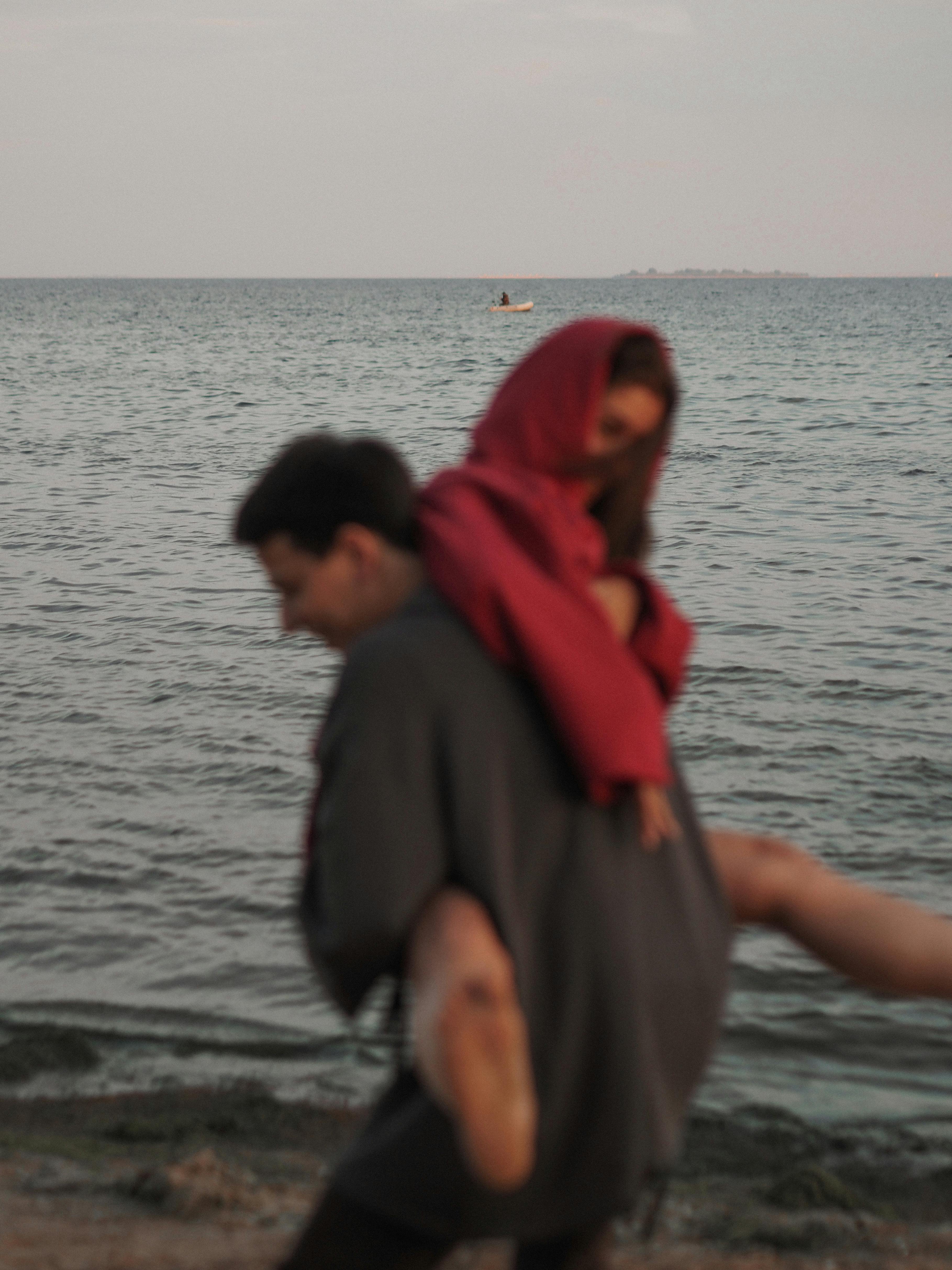 日落时分，年轻夫妇在海边享受嬉戏的时刻