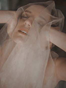 Serene portrait of a woman with closed eyes and sheer veil, exuding calmness and beauty.