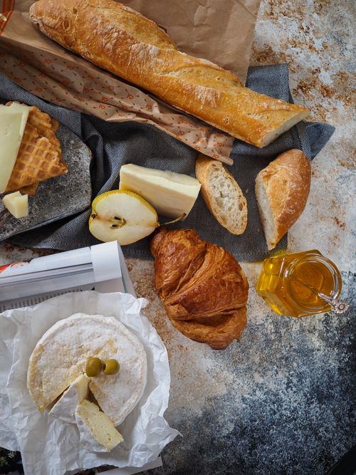 Free Flat lay of a French breakfast with croissant, baguette, cheese, and honey for a gourmet start. Stock Photo
