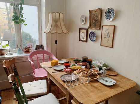 Charming indoor dining area with diverse decor and a ready-to-serve table setting.