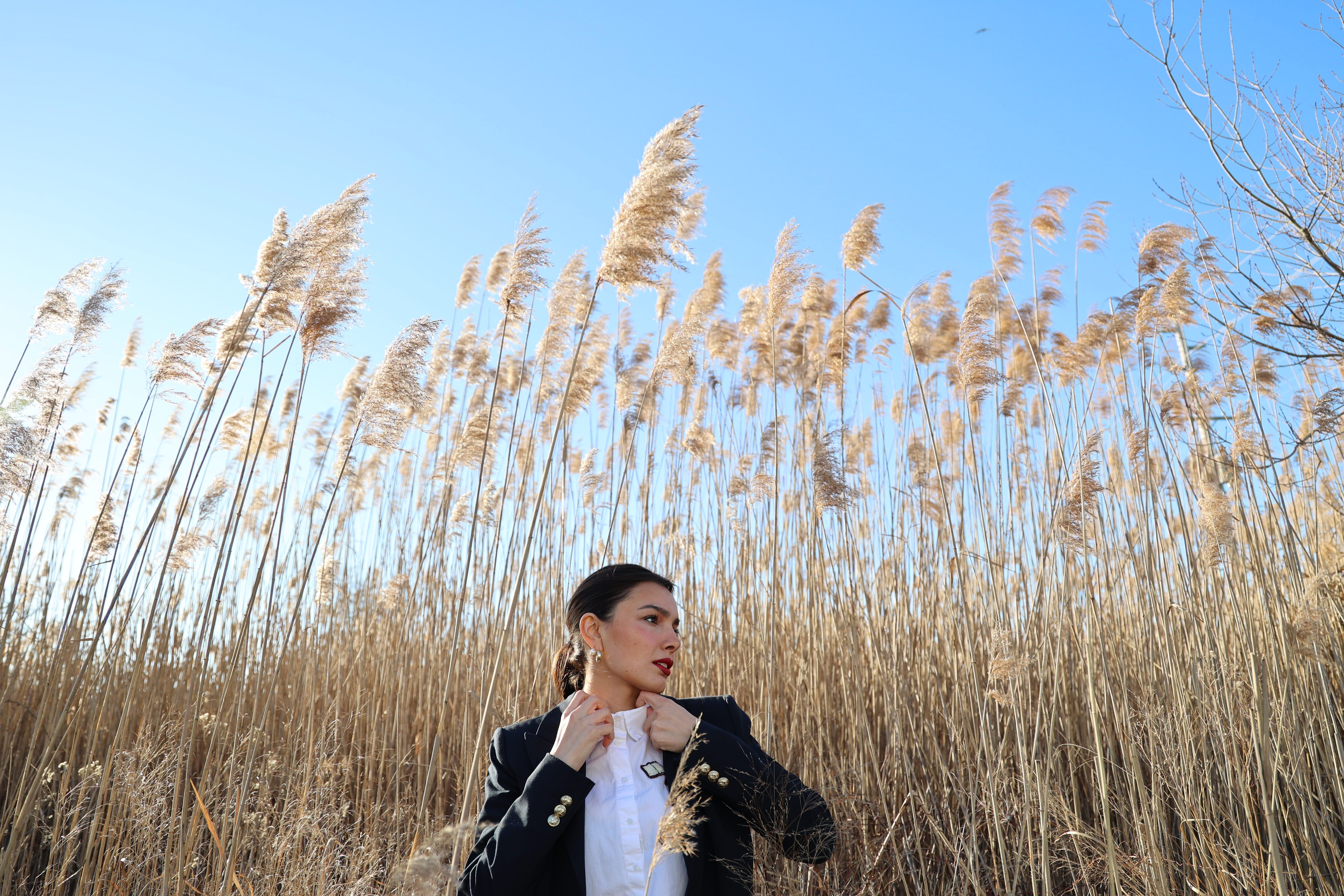 A Woman in Black Jacket Standing on Brown Grass Field · Free Stock Photo