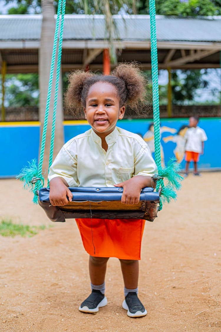 A Child Playing On The Swing