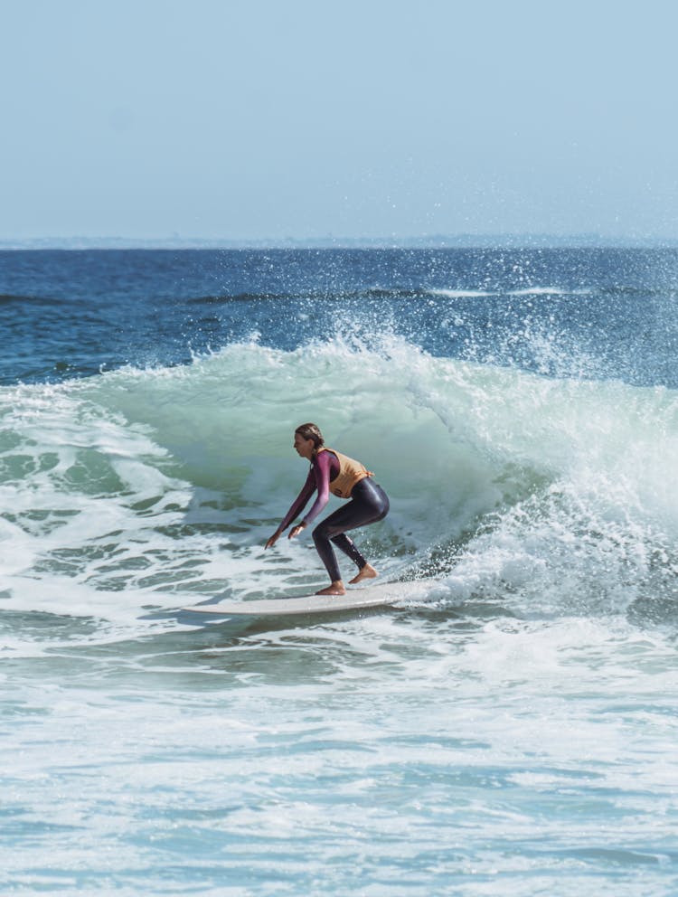 Woman In Black Wetsuit Surfing On Sea Waves