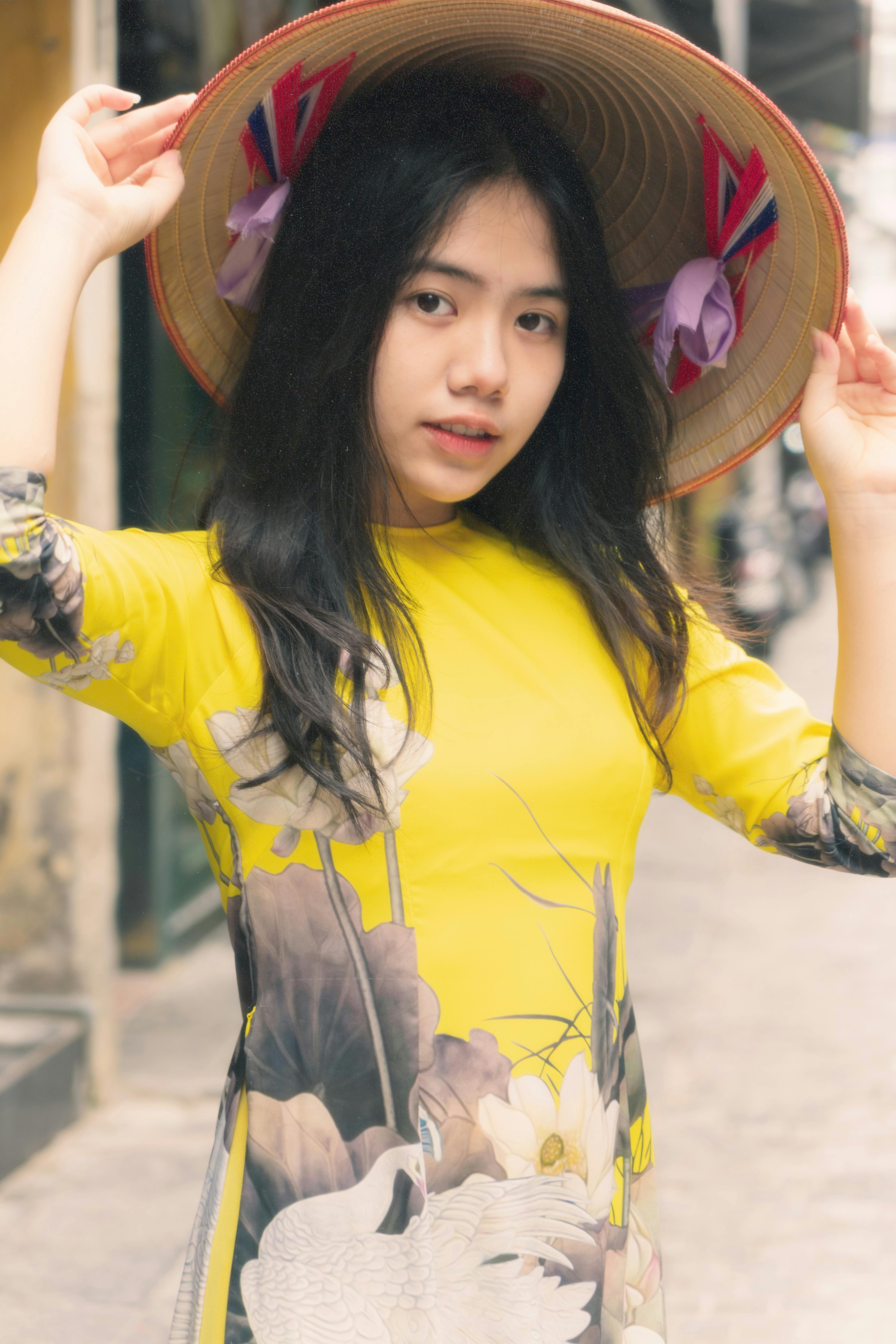 a pretty woman in yellow dress wearing a hat