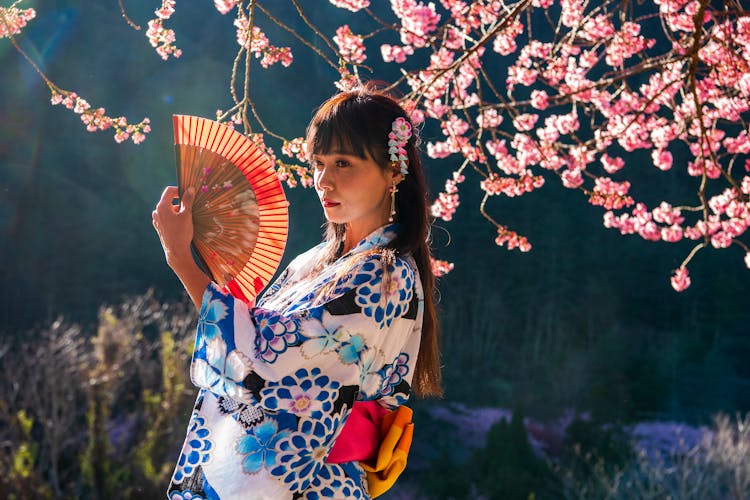 A Woman Holding A Fan