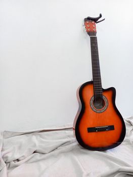 Classic acoustic guitar with a capo on a blanket, perfect for music and instrument themes.