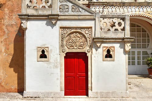 Red Wooden Door on White Concrete Building