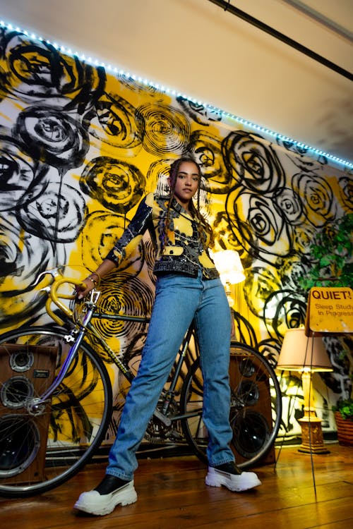 Woman in Denim Jeans Standing Beside a Bicycle