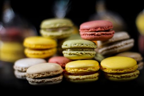 Free Delicious assorted macarons in vibrant colors, artfully arranged on a dark background. Perfect for dessert lovers. Stock Photo