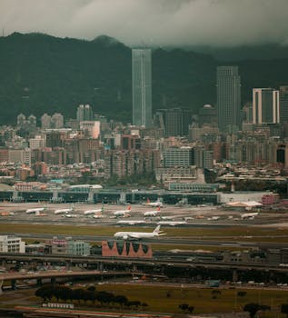 Breathtaking aerial view of a city skyline with bustling airport in the foreground, under a moody sky.