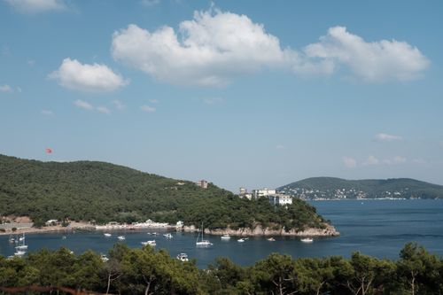 Free Beautiful landscape of a lush island with yachts and sailboats in a peaceful bay. Stock Photo