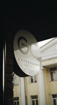 Elegant barber shop sign with logo on urban storefront, capturing a modern city vibe. 11169544