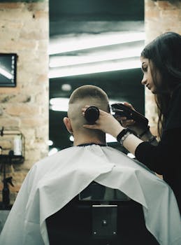A hairdresser expertly cutting a man's hair in a stylish barber shop with modern decor.