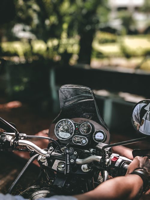 Free High angle view of motorcycle dashboard and handlebars with rider's hands outdoors. Stock Photo