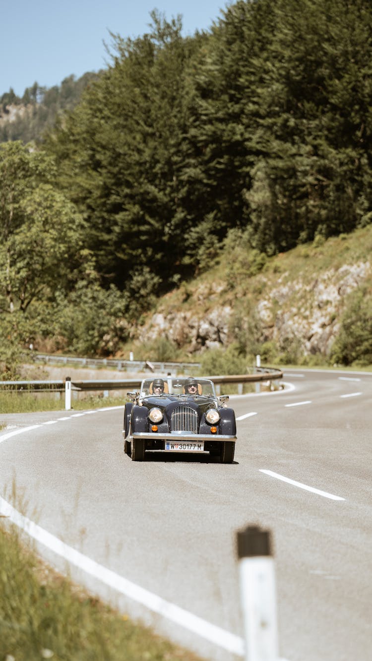 Vintage Car Driving Down Curvy Road