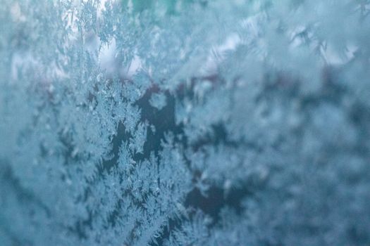 Close-up of intricate frost patterns on a cold winter window.