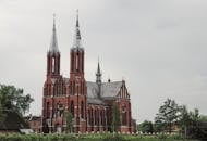 一座古色古香的小镇上，一座美丽的哥特式大教堂尖顶高耸，映衬着多云的天空