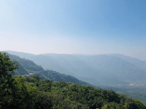 Captivating misty hills and lush greenery in Olavan, India, showcasing a tranquil rural landscape.
