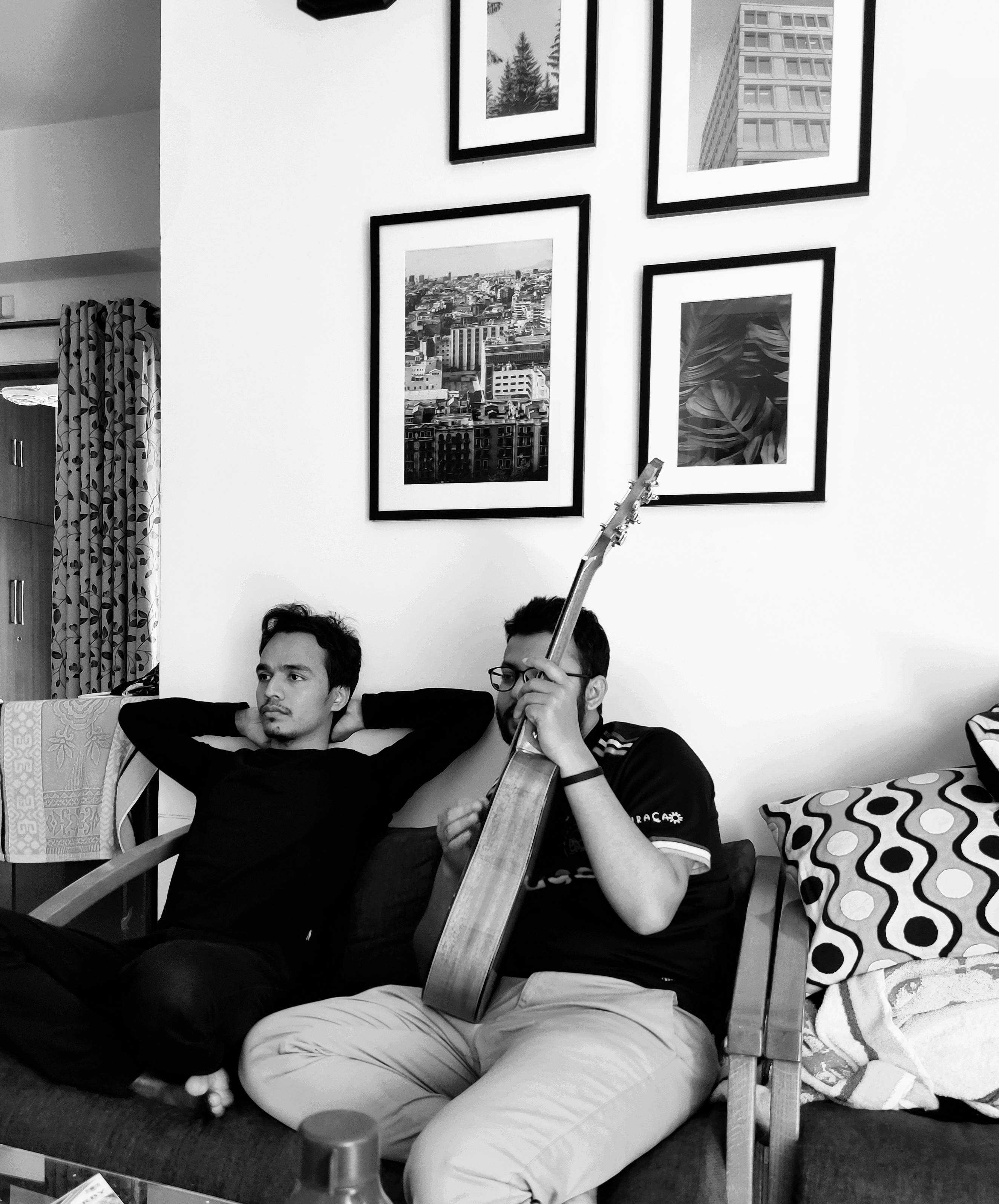 a grayscale of men sitting in a living room