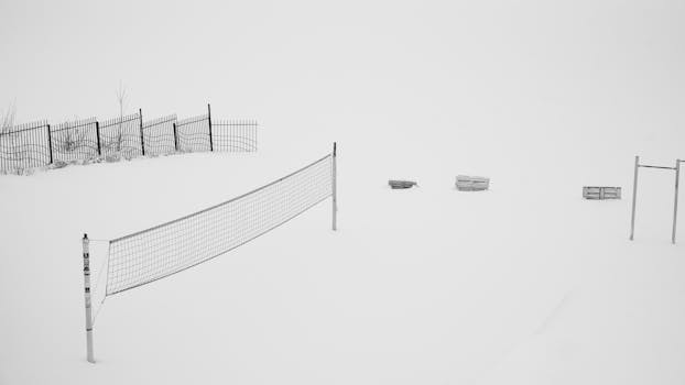A serene, snowy volleyball court in a minimalist winter landscape.