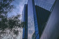 低角度拍摄新西兰惠灵顿多云天空下的现代玻璃摩天大楼