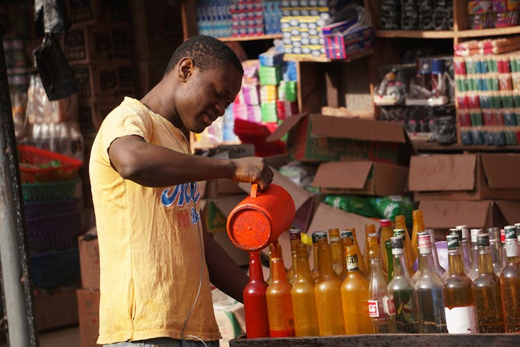 Man Pouring Liquid To Bottles