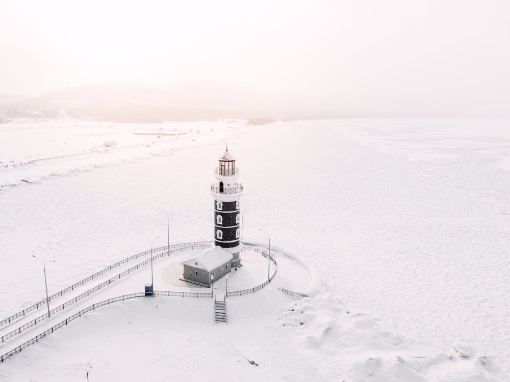 Lighthouse Among Snow and Frozen Coast 