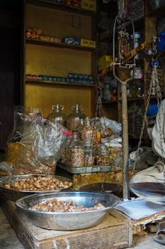 An indoor market stall with bowls of dry goods and vintage scales, offering a rustic shopping experience.