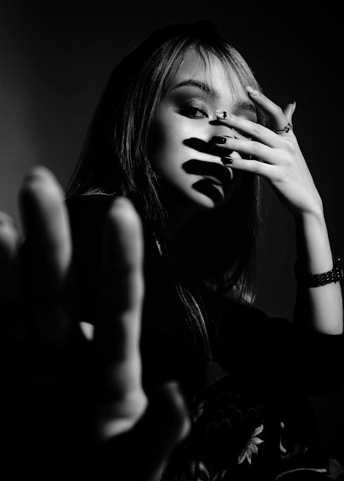 Grayscale Photo of Woman Covering Her Face