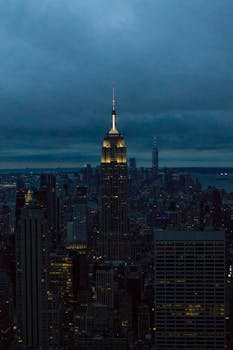 View of New York City's skyline at night, featuring the iconic Empire State Building.