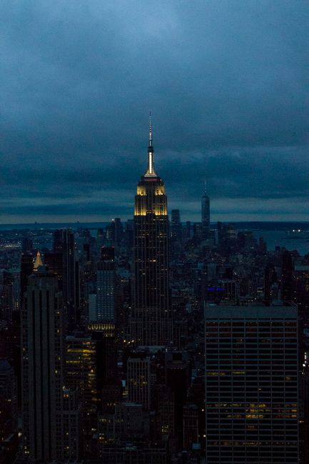View of New York City's skyline at night, featuring the iconic Empire State Building.