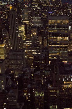 Captivating aerial night view of New York City's illuminated skyscrapers, showcasing vibrant city life.