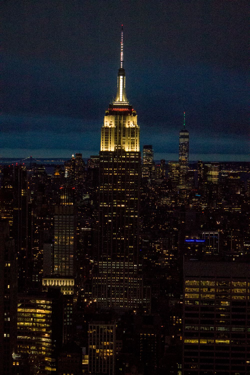 Empire State Building iluminado en la noche dominando el skyline de Manhattan