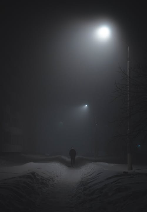 

A Man Walking on a Snow Covered Pathway