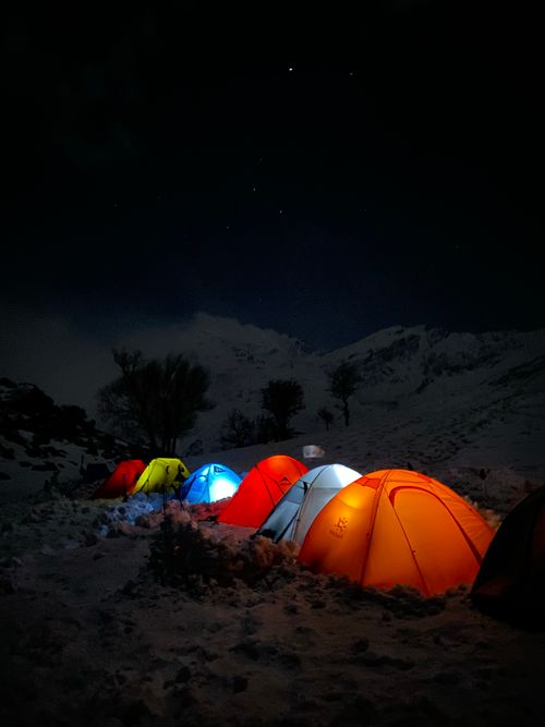 Free A stunning nighttime scene of illuminated tents set against a snowy backdrop in Iraq, perfect for adventure themes. Stock Photo