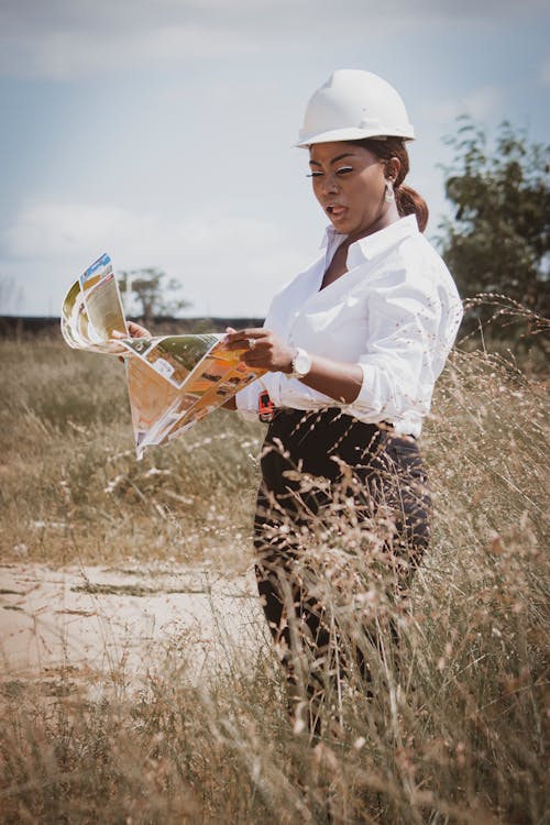 Woman Wearing a Hardhat Looking at a Map