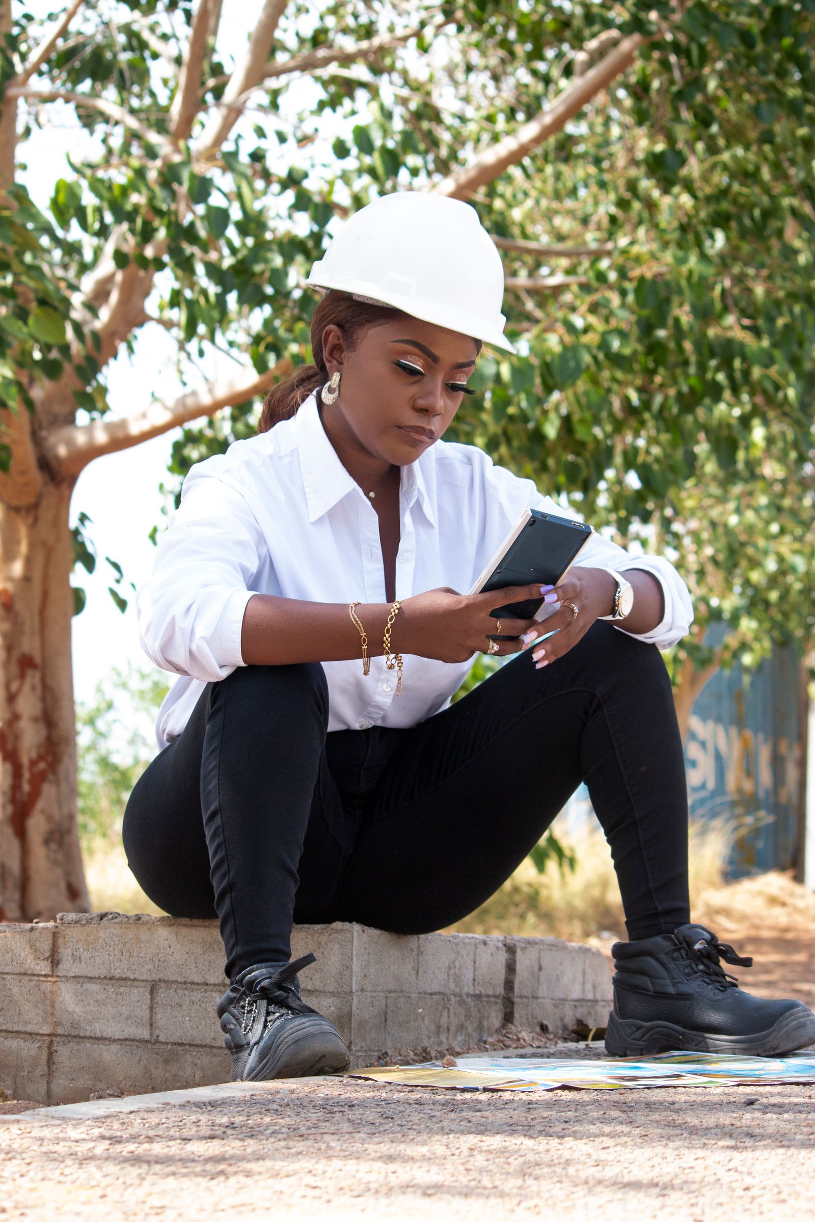 Engenheira em obra utilizando smartphone para comunicação e gestão