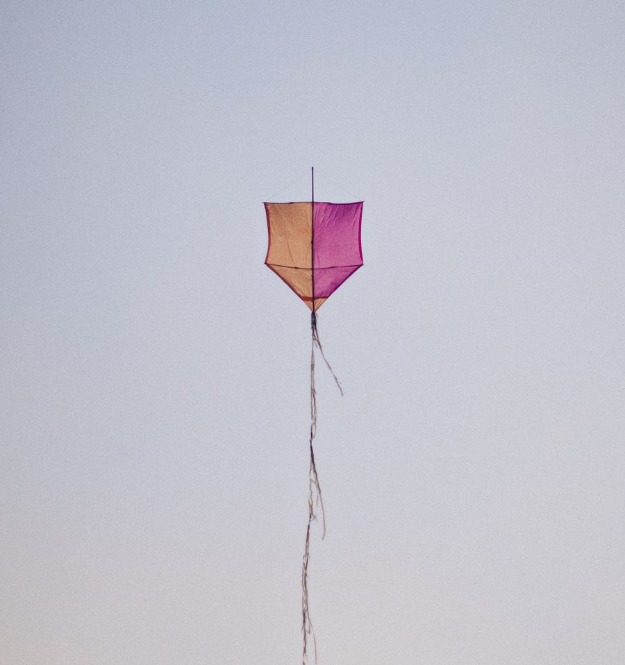 Bright kid-friendly colorful kite flying in a serene blue sky