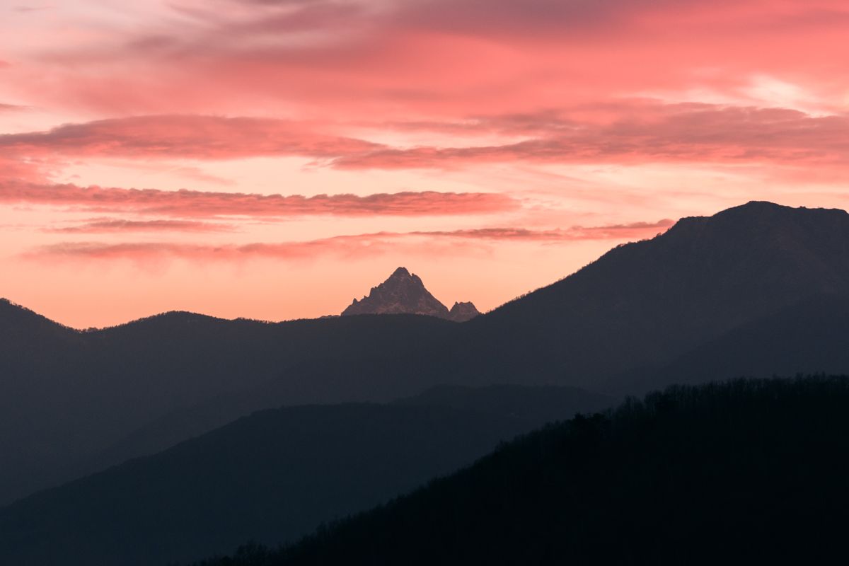 Cielo rosado de atardecer sobre una cadena de montañas