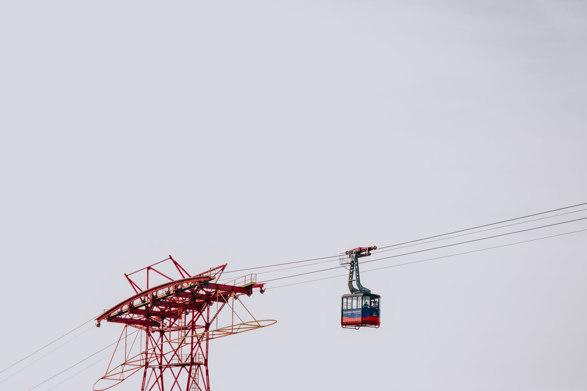 Cabinas de un teleférico urbano llegando a una estación elevada sobre una ciudad